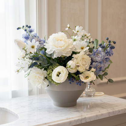 Blue Sunshine centerpiece rental with white peonies, blue hydrangea, blue delphinium, white garden roses, and white cosmos in gray bowl vase on white marble vanity in elegant bridal suite with soft natural window light | Reno, Lake Tahoe & Sacramento