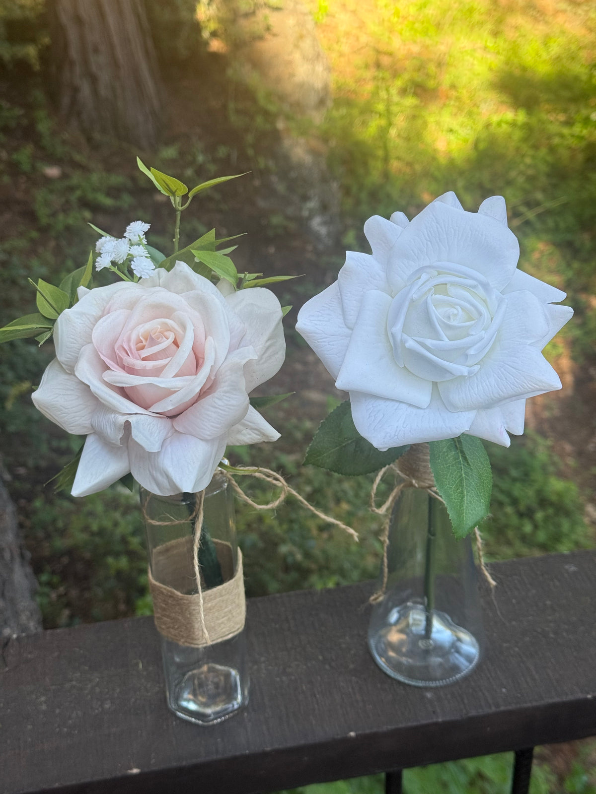Blush and white rose centerpiece rentals in glass bud vases with twine wrap and baby's breath displayed outdoors in natural sunlight | Reno, Lake Tahoe & Sacramento