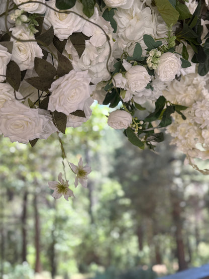 Close-up of Daydream arch rental floral detail showing white garden roses, hydrangea, clematis, and lush greenery with pine tree backdrop | Reno, Lake Tahoe & Sacramento
