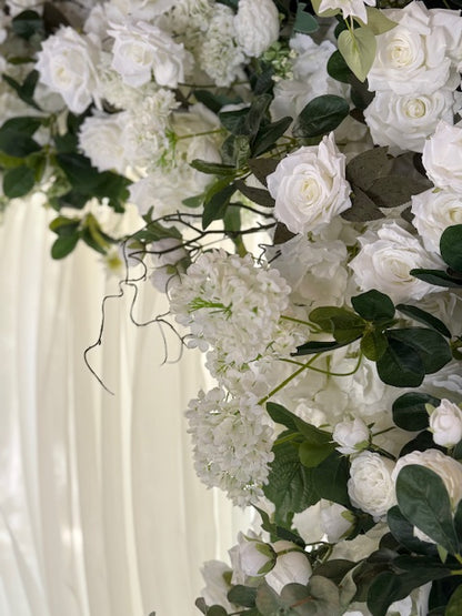 Close-up of Daydream arch rental floral detail showing white garden roses, hydrangea, clematis, and lush greenery with pine tree backdrop | Reno, Lake Tahoe & Sacramento