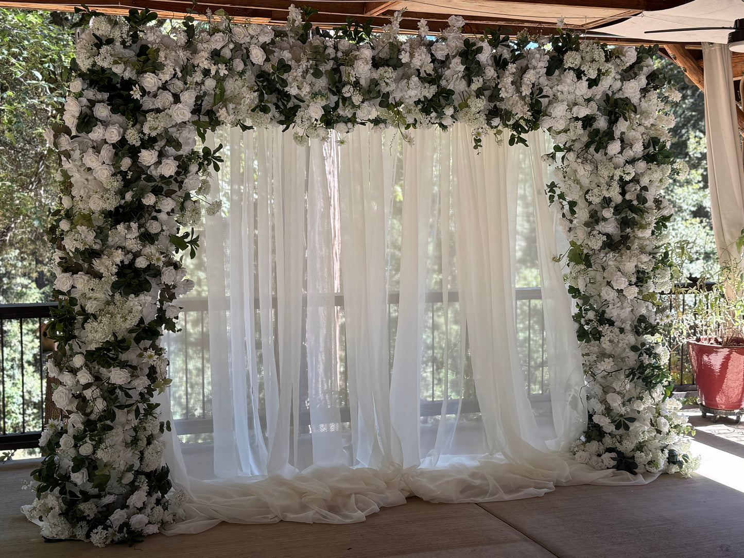 Full Daydream arch rental with white roses, hydrangea, greenery, and flowing white chiffon drapery at outdoor redwood forest wedding venue | Reno, Lake Tahoe & Sacramento