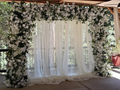Full Daydream arch rental with white roses, hydrangea, greenery, and flowing white chiffon drapery at outdoor redwood forest wedding venue | Reno, Lake Tahoe & Sacramento