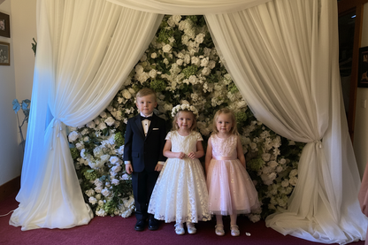 Three children posing in front of Daydream flower wall rental with white roses, white hydrangea, and lush greenery at indoor event | Reno, Lake Tahoe & Sacramento