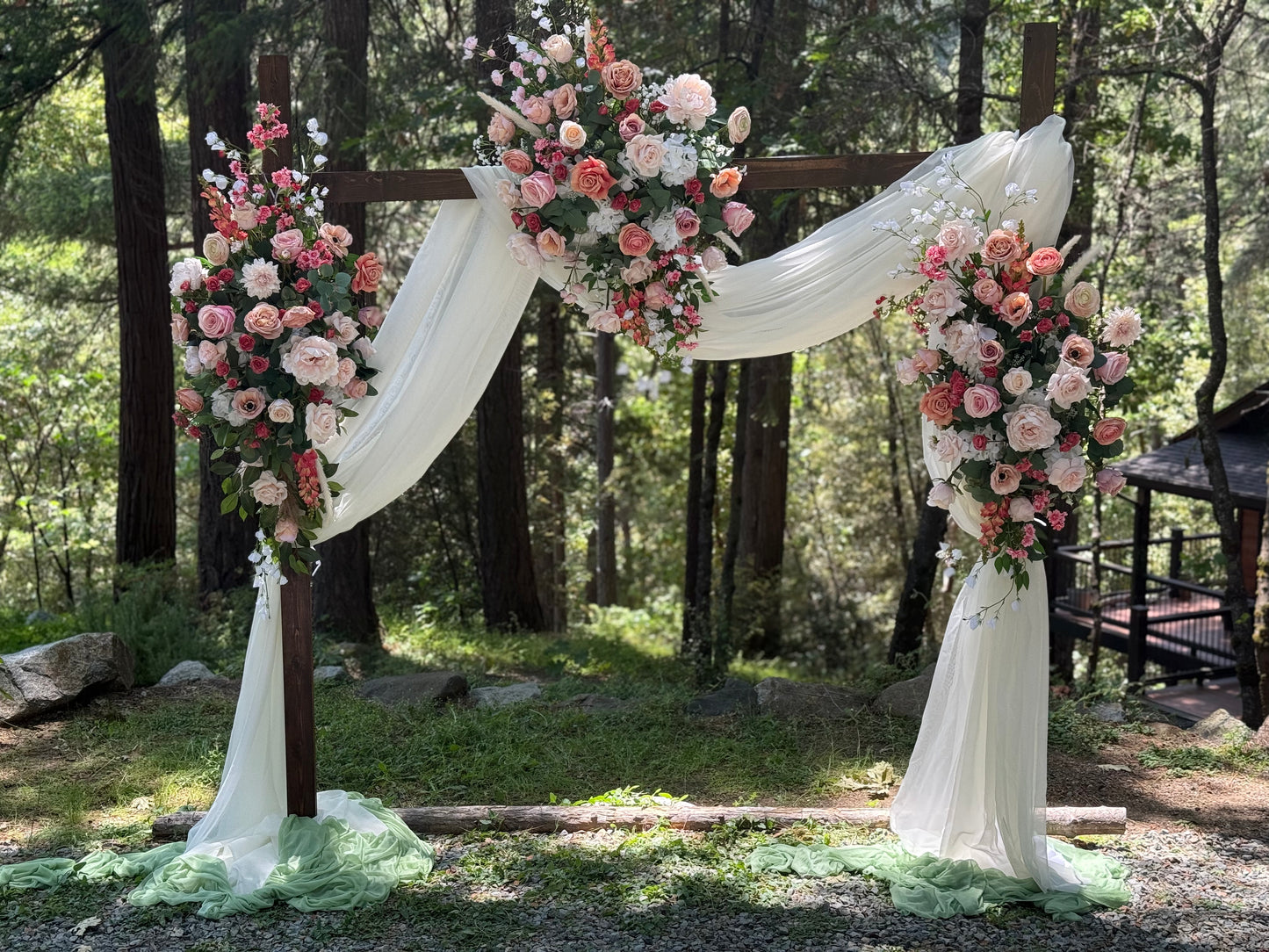 Full setup of Delicate arch adornment rental with blush and white florals cascading down rustic wood arch with white drapery | Reno, Lake Tahoe & Sacramento