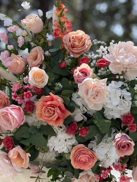 Close-up of Delicate arch adornment rental with blush garden roses, ranunculus, anemones, and white florals cascading down rustic wood arch | Reno, Lake Tahoe & Sacramento
