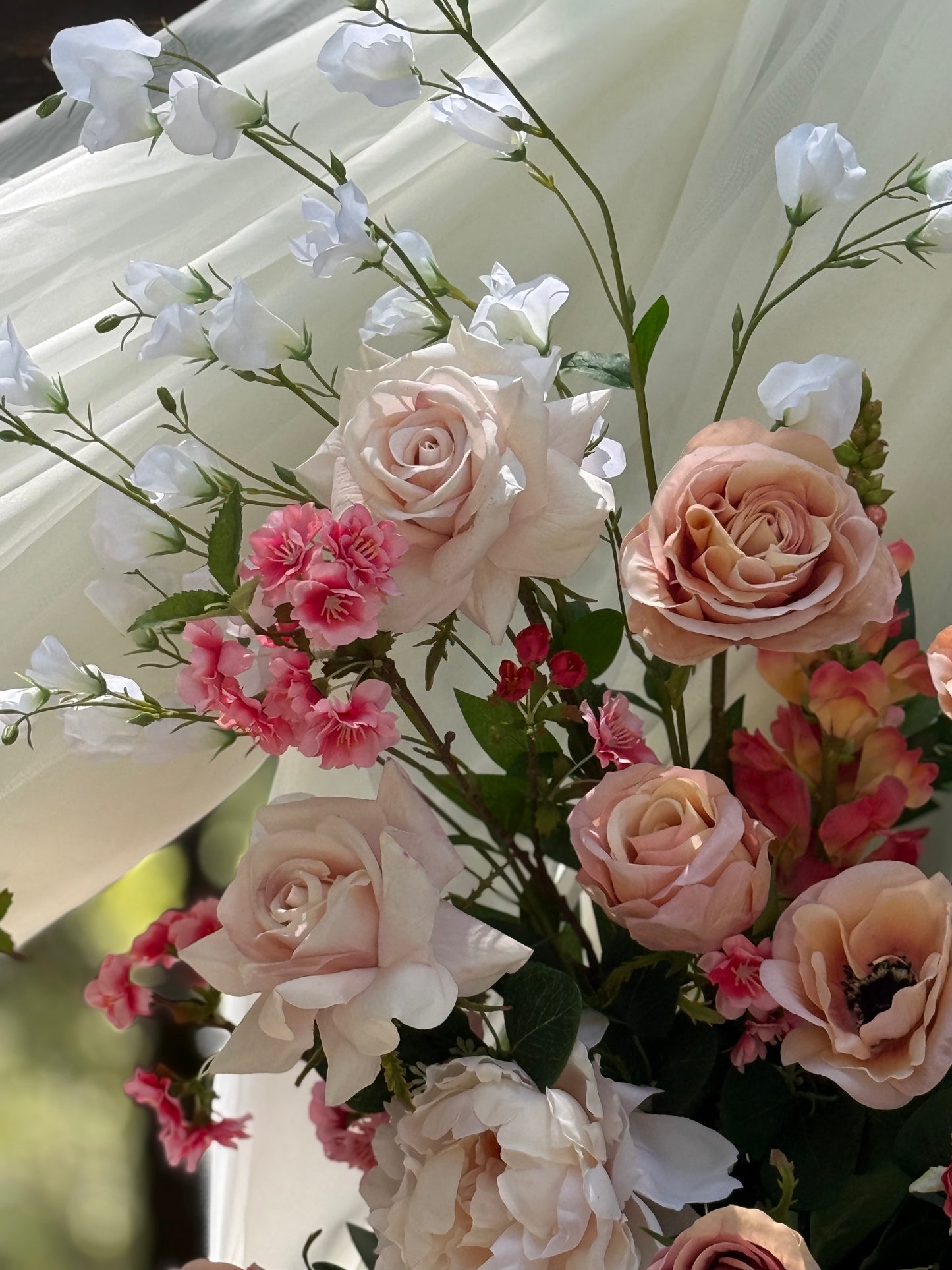 Close-up of Delicate arch adornment rental with blush garden roses, anemones, sweet peas, ranunculus, snapdragons and pink spray roses in bright natural sunlight | Reno, Lake Tahoe & Sacramento