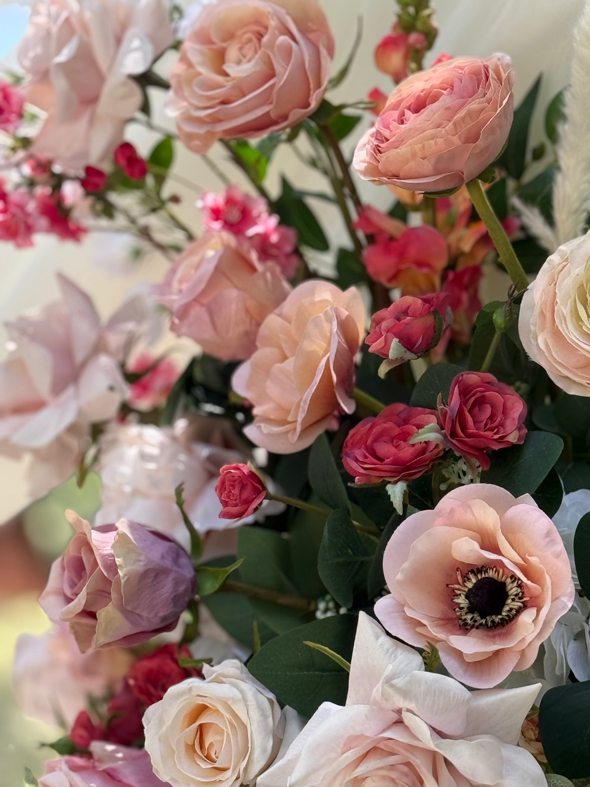 Macro close-up of Delicate arch adornment rental showing blush garden roses, anemones, ranunculus, and coral spray roses in soft natural light | Reno, Lake Tahoe & Sacramento