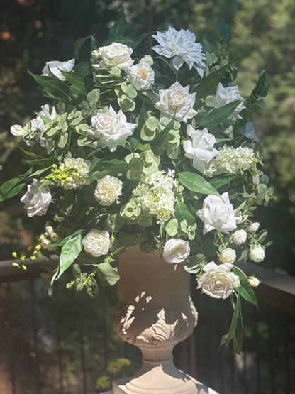 Enchanted floral stone urn rental on wood deck railing with white roses, white dahlias, white hydrangea, white ranunculus, and cascading eucalyptus in dappled sunlight at outdoor pine forest wedding venue | Reno, Lake Tahoe & Sacramento
