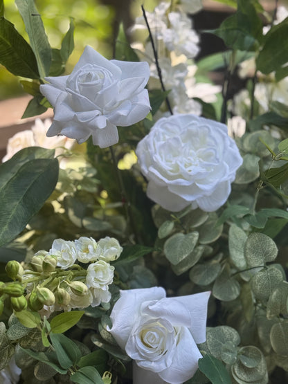 Macro close-up of Enchanted urn rental blooms with white garden roses, white ranunculus, and white hydrangea buds with lush eucalyptus in dappled outdoor light | Reno, Lake Tahoe & Sacramento
