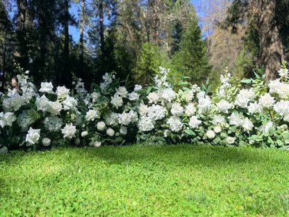 Full row of Enchanted aisle flower rentals lining outdoor pine forest wedding ceremony grass aisle with white roses, white hydrangea, white delphinium, and eucalyptus | Reno, Lake Tahoe & Sacramento

