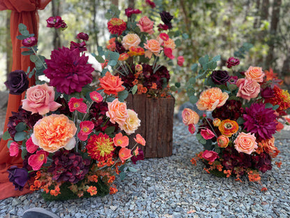 Close-up of 3 Evermore Fall aisle flower rentals with coral garden roses, burgundy dahlias, orange ranunculus, and eucalyptus at outdoor redwood forest wedding | Reno, Lake Tahoe & Sacramento