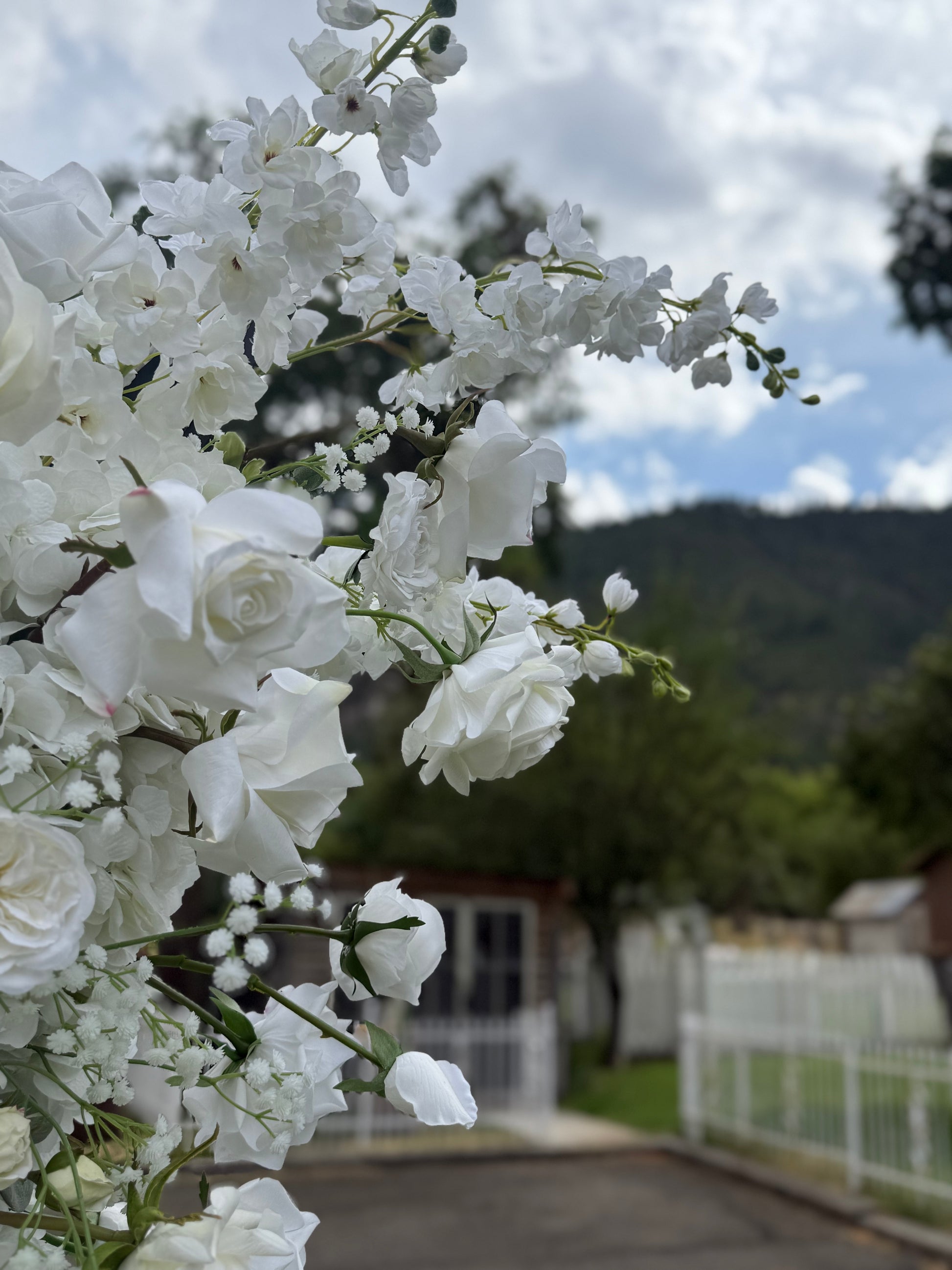Close-up of Fairytale double moon arch rental blooms with white garden roses, white delphinium, and baby's breath at outdoor mountain wedding venue | Reno, Lake Tahoe & Sacramento