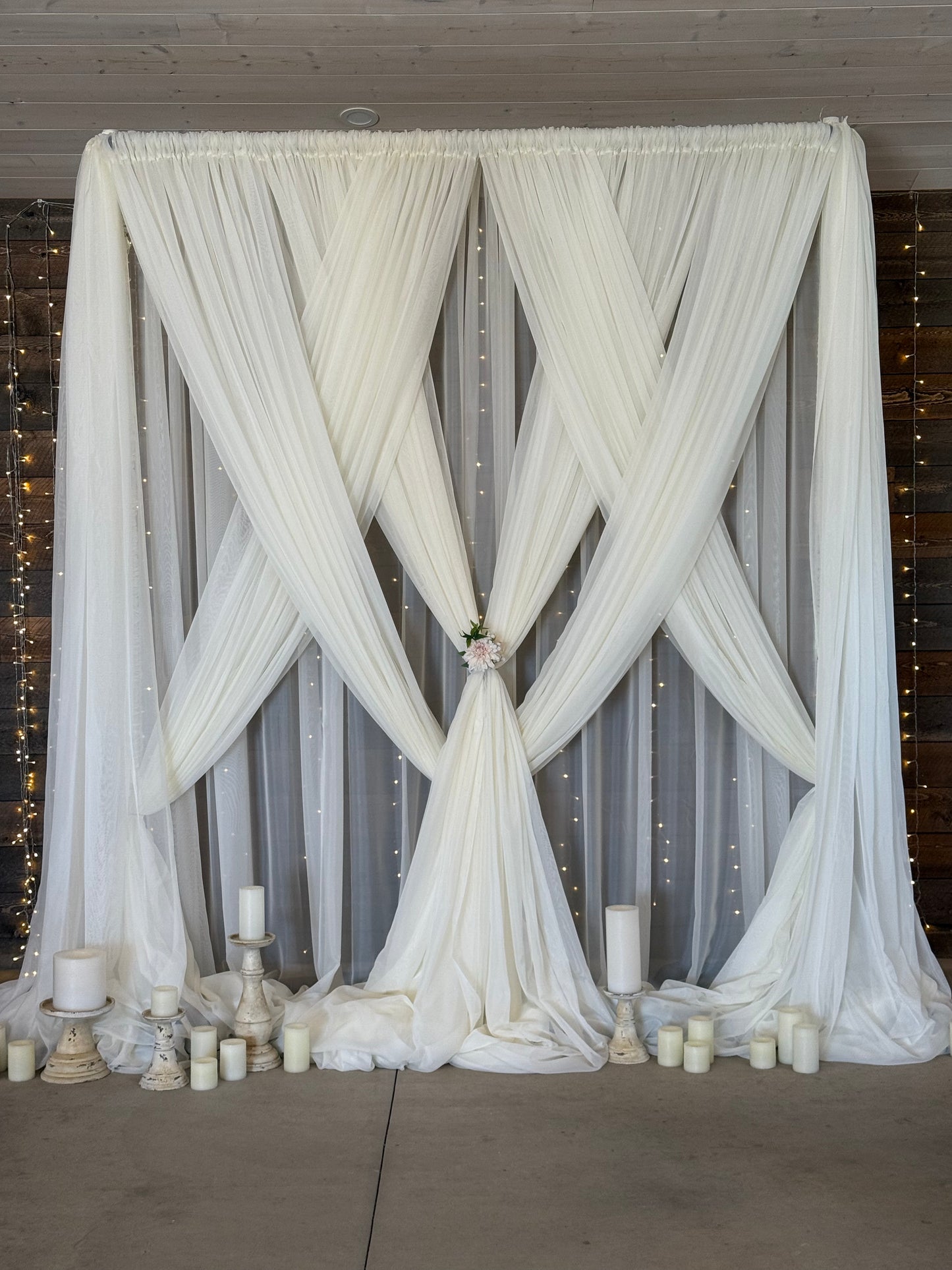 12-foot twinkle curtain light rental as full backdrop with white drapery, candles, and floral tie at indoor barn wedding ceremony | Reno, Lake Tahoe & Sacramento