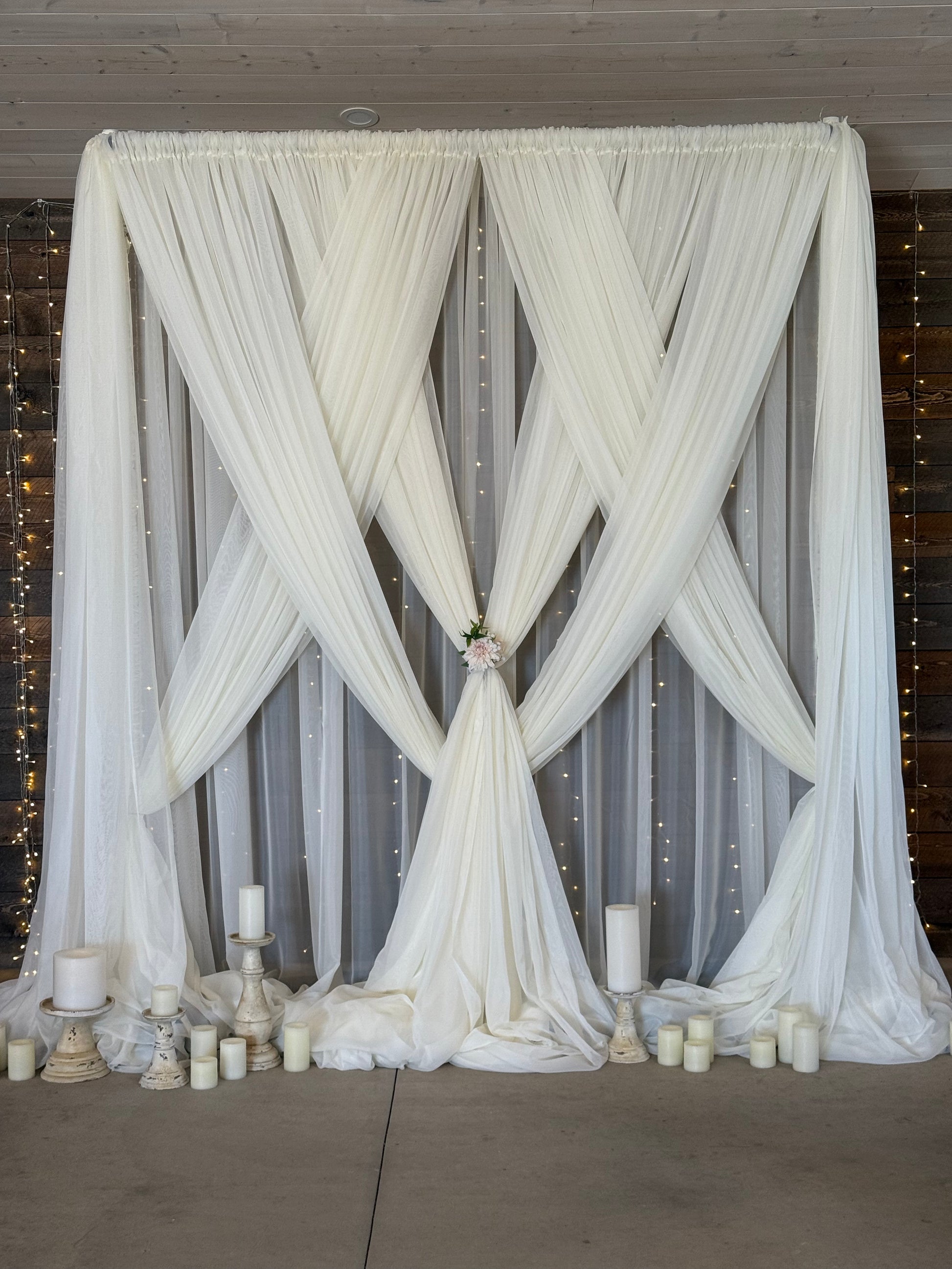 12-foot twinkle curtain light rental as full backdrop with white drapery, candles, and floral tie at indoor barn wedding ceremony | Reno, Lake Tahoe & Sacramento