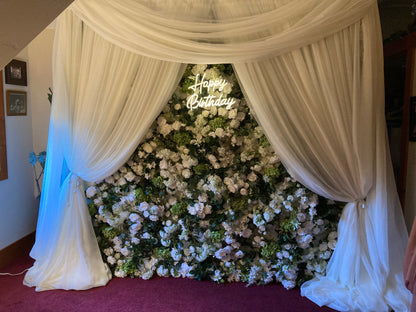 LED light-up neon sign rental mounted on white and green flower wall backdrop with white drapery at indoor event | Reno, Lake Tahoe & Sacramento