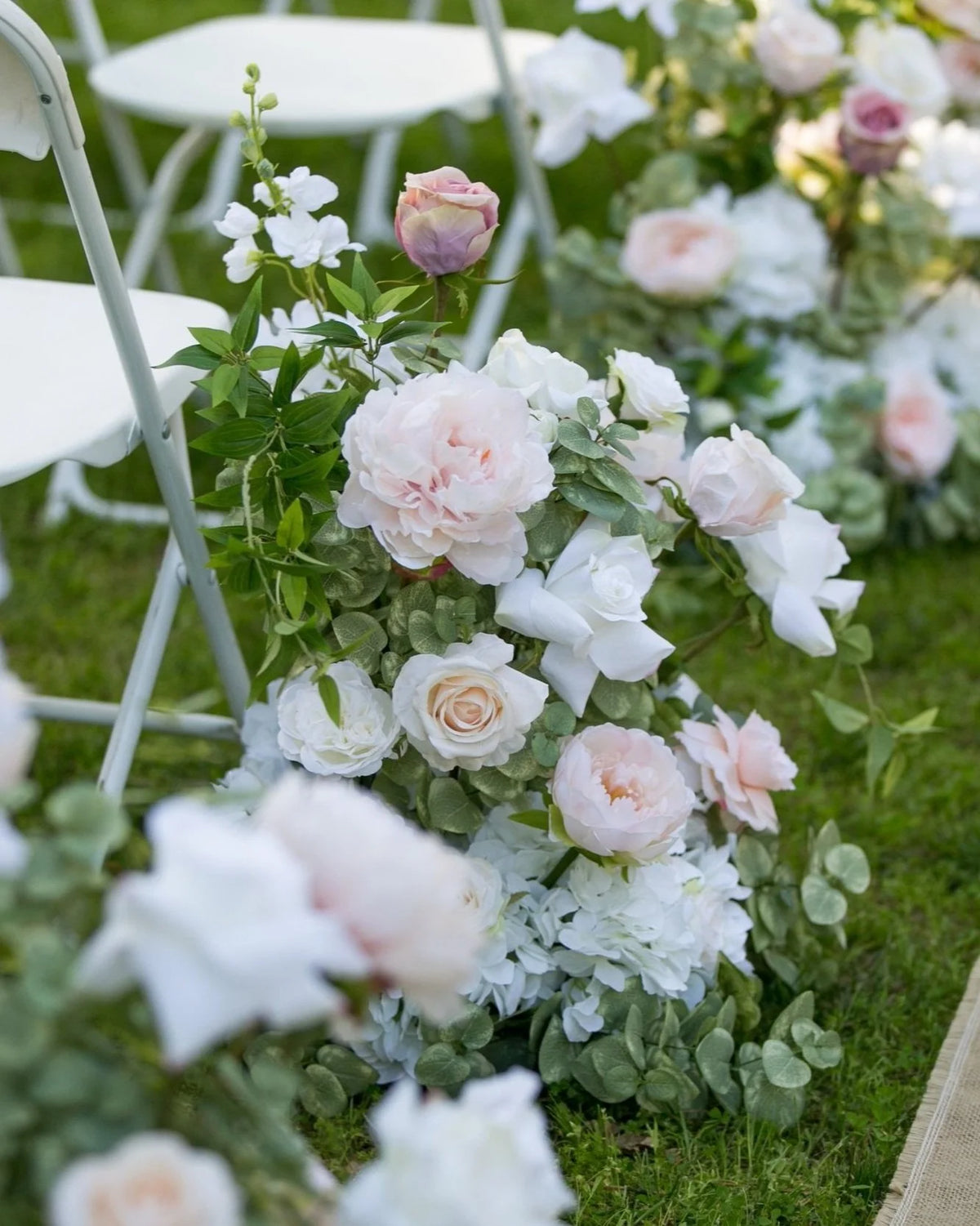 Close-up of blush and white aisle flower rental with garden roses, hydrangea, and eucalyptus at outdoor wedding ceremony | Reno, Lake Tahoe & Sacramento