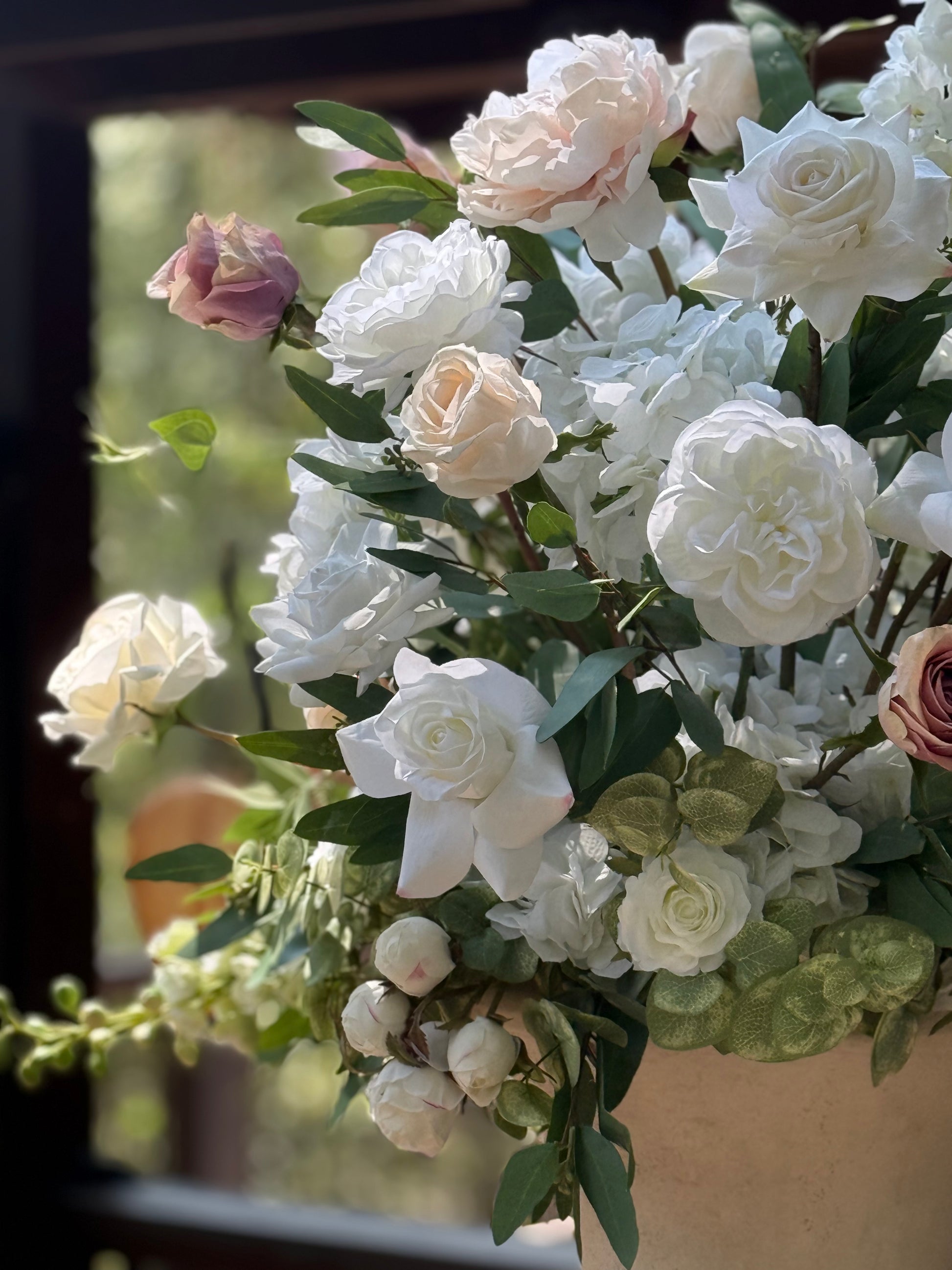 Close-up of Love Story urn rental blooms with white peonies, cream roses, white gardenias, blush hydrangea, and mauve rose buds at indoor wedding venue | Reno, Lake Tahoe & Sacramento