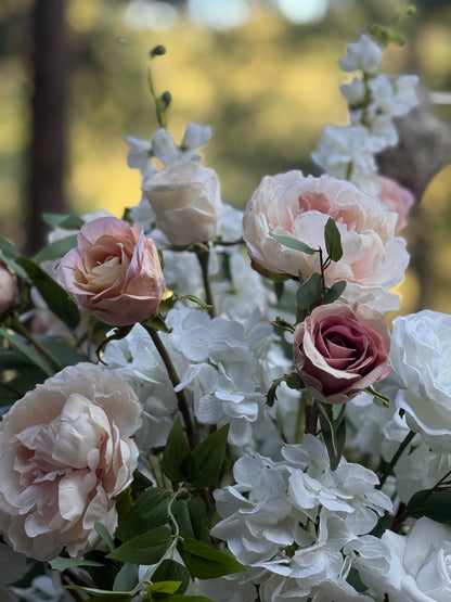 Close-up of Love Story floral stone urn rental overflowing with blush peonies, white hydrangea, cream roses, and cascading greenery at golden hour pine forest wedding venue | Reno, Lake Tahoe & Sacramento