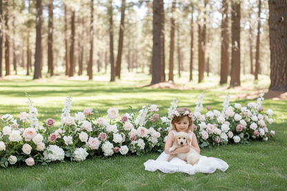 Flower girl with floral crown holding golden retriever puppy in front of Love Story aisle flower meadow with blush, mauve, and white roses at outdoor pine forest wedding venue | Reno, Lake Tahoe & Sacramento