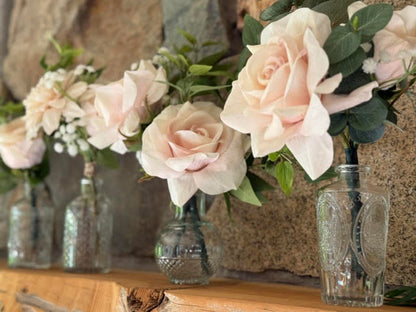 Blush garden rose centerpiece rentals with baby's breath and eucalyptus in crystal bud vases displayed on rustic stone ledge at outdoor wedding venue | Reno, Lake Tahoe & Sacramento