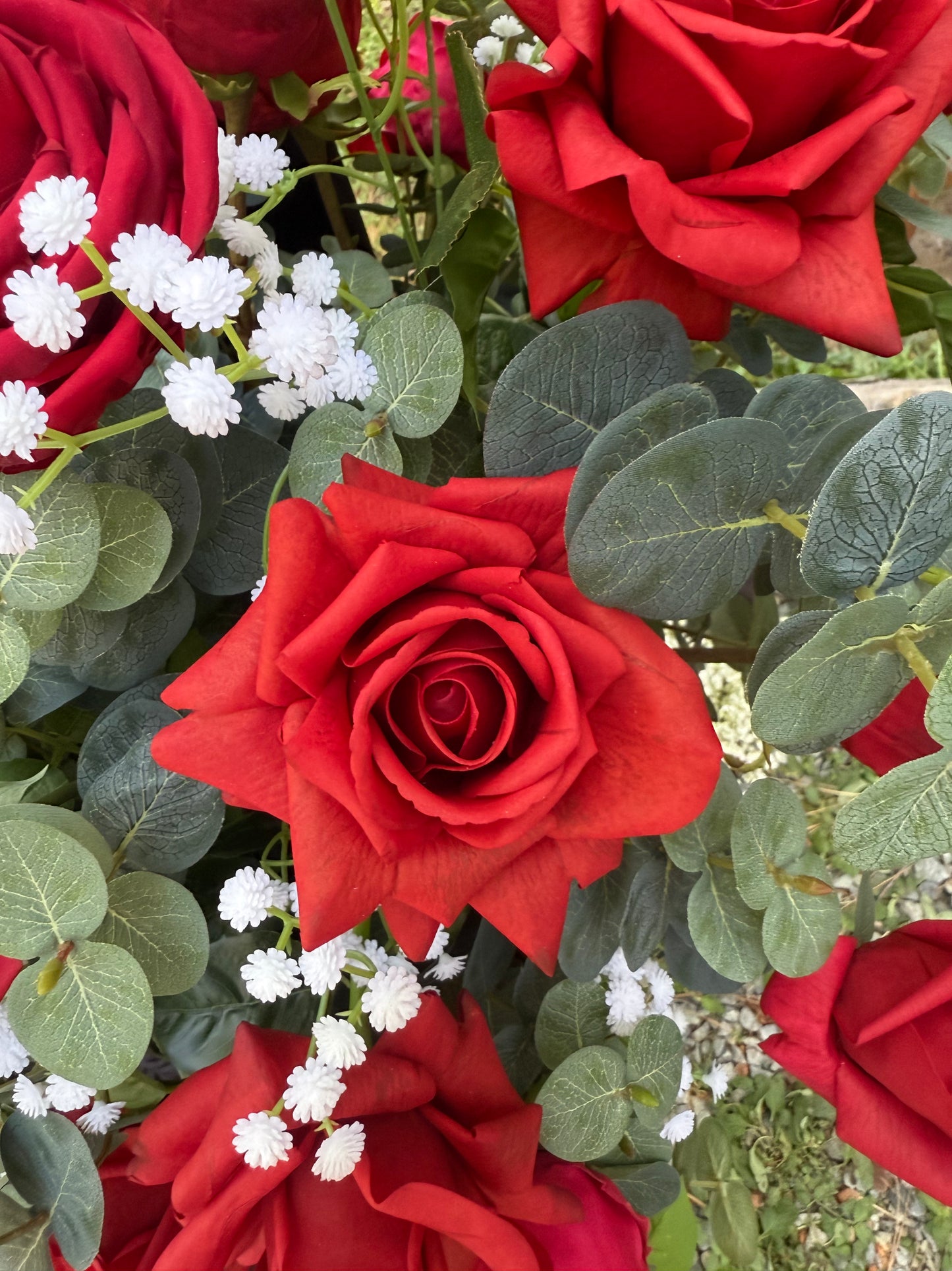 Close-up of red rose and baby's breath floral detail in black urn rental with eucalyptus at outdoor wedding ceremony | Reno, Lake Tahoe & Sacramento