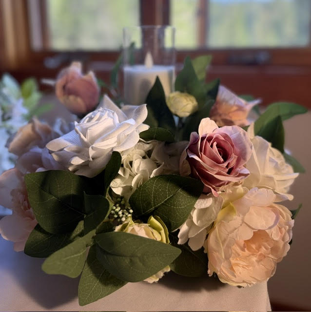 Small Love Story Centerpiece with lit candle on white tablecloth