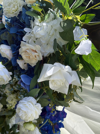 Close-up of Sweet Nothings arch adornment rental with white garden roses, blue hydrangea, and navy delphinium with white drapery in bright sunlight | Reno, Lake Tahoe & Sacramento