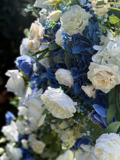 Close-up of Sweet Nothings arch adornment rental with white garden roses, blue hydrangea, and navy delphinium with white drapery in bright sunlight | Reno, Lake Tahoe & Sacramento