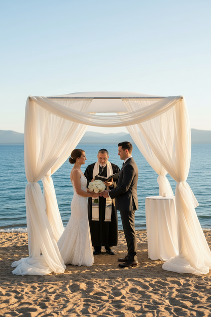 Chuppah rental with white chiffon drapery and floral canopy top with couple and rabbi at cocktail table at outdoor Lake Tahoe wedding venue | Reno, Lake Tahoe & Sacramento