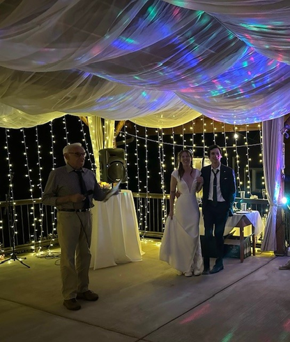 12-foot twinkle curtain light rental creating warm glowing backdrop behind bride and groom at outdoor evening wedding reception with draped ceiling | Reno, Lake Tahoe & Sacramento