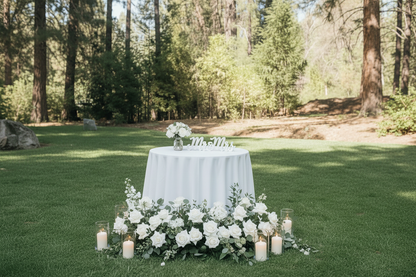 Enchanted aisle flower rentals styled as sweetheart table ground florals with white roses, eucalyptus, and pillar candles at outdoor pine forest wedding venue with Mr & Mrs sign | Reno, Lake Tahoe & Sacramento